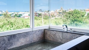 A modern bathroom with a large window, a marble sink, and a view of a cityscape. - White House (Liuqiu)