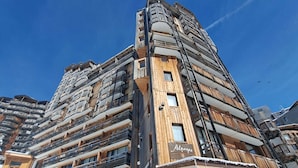 Un hôtel à plusieurs étages, doté de balcons et d’une façade en bois.