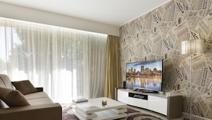 Ein modernes Wohnzimmer mit Stadtblick-Fernseher, einer Couch, einem Couchtisch und einer Wand mit Muster.