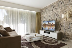 Appartamento Deluxe | Soggiorno | TV a schermo piatto 32 pollici con canali via cavo, lettore DVD