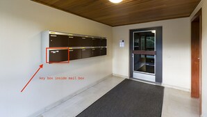 Ein Korridor mit Holzboden und einem an der Wand befestigten Briefkästen-System.