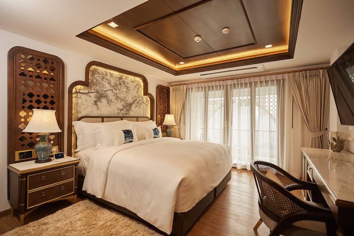 Ein Hotelzimmer mit einem großen Bett, einem Schreibtisch und einem Fernseher.