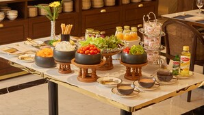Una mesa de buffet con diversos alimentos y salsas.