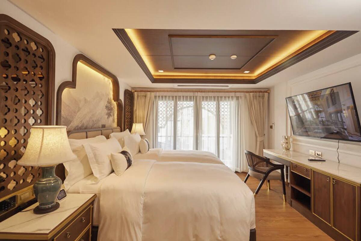 Ein Hotelzimmer mit einem großen Bett, einem Schreibtisch und einem Fernseher.
