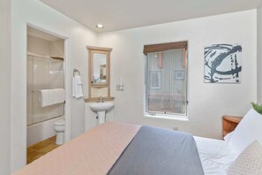 A modern bedroom with a bed, a window with curtains, a bathroom with a shower, and a sink. - Awesome Views; Ski In/Out & lift is 100 steps from the Door (Telluride)