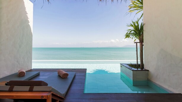 A private pool area with a view of the ocean, a lounge chair, and a small planter with a palm tree. - The Flow Samui Beach Resort (Koh Samui)
