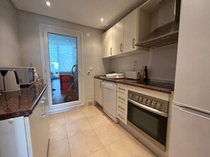 Cocina compacta con lavavajillas, horno y microondas.