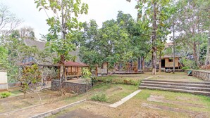Ein Innenhof mit einem Steinweg, einem kleinen Garten und einer Holzterrasse.