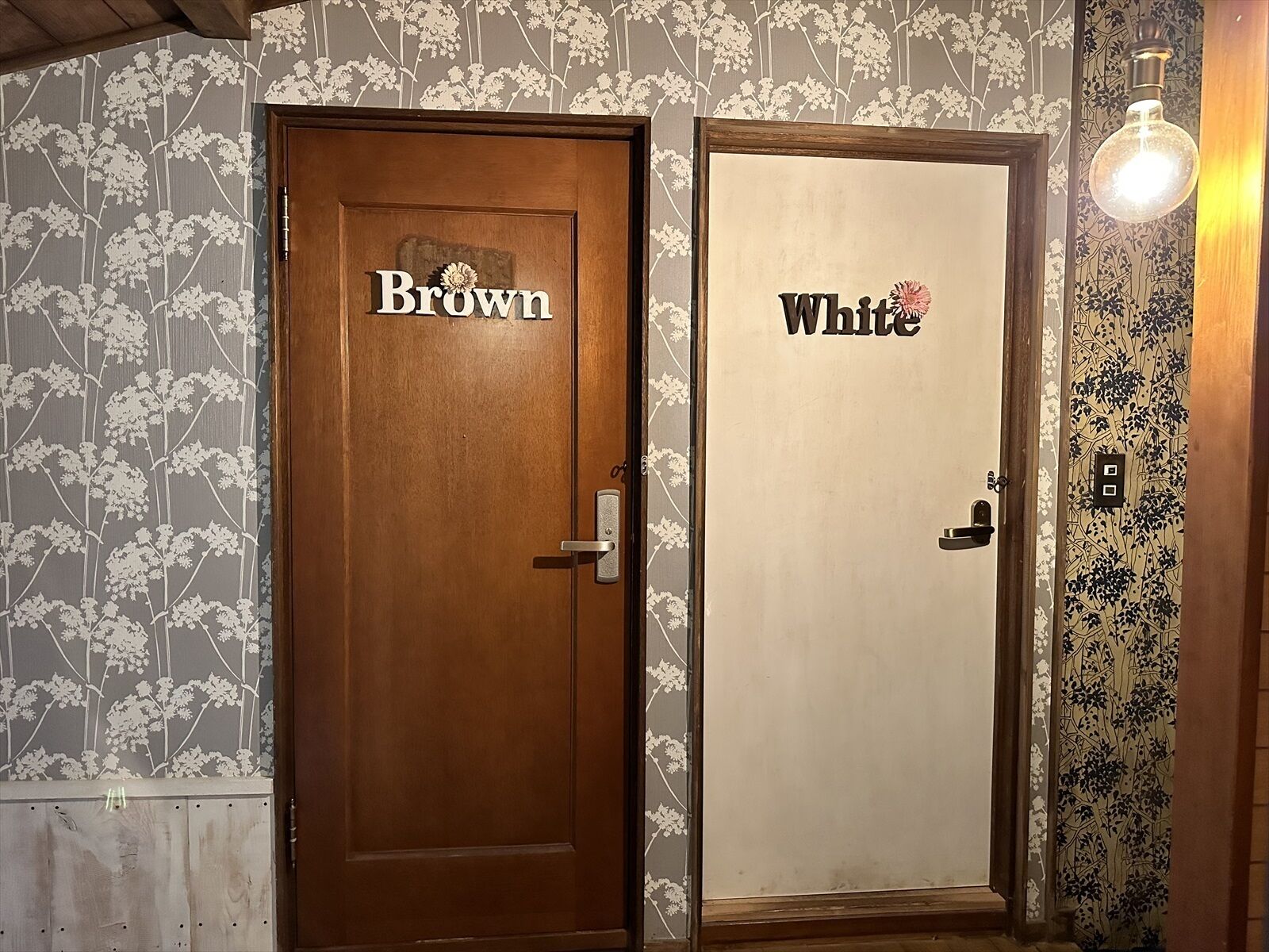 Two doors labeled 'Brown' and 'White' with floral wallpaper and a hanging light fixture.