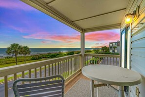 A balcony with a view of the ocean and a table.