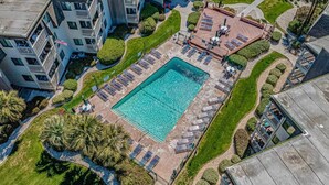 An aerial view of a hotel with a central swimming pool surrounded by sun loungers and a patio area. - Ocean Forest Villas Unit E210 - Oceanfront (Myrtle Beach)