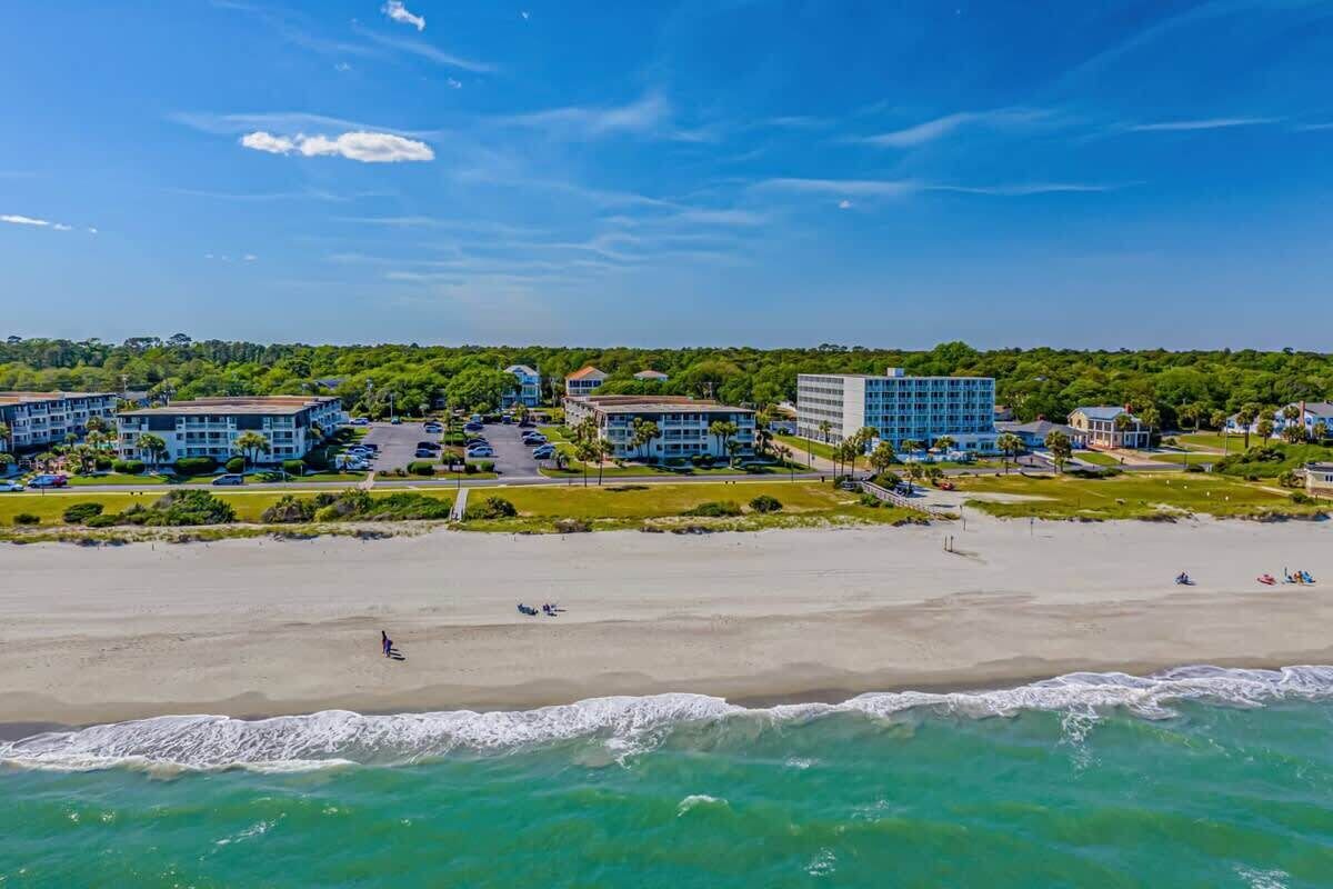 Ein Küstenhotel mit mehreren Gebäuden, einem Sandstrand und Blick auf den Ozean.