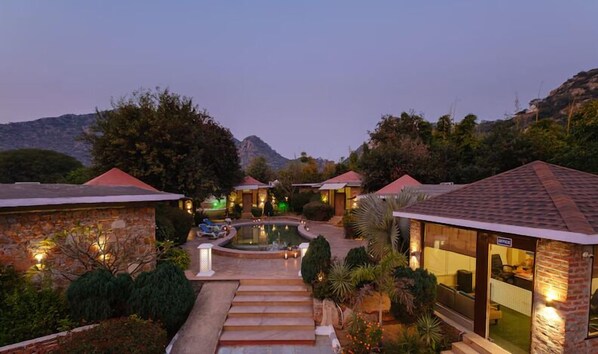 Un resort con varias villas para huéspedes, una piscina y una escalera de piedra que conduce a las villas.