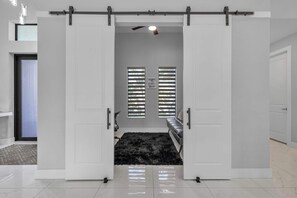 A room with a sliding door, a black rug, and a bench.