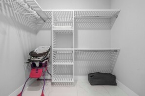 Un meuble de rangement blanc, doté d’étagères et d’une poussette.