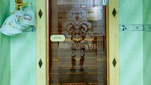 A door with a decorative glass panel and a sign above it. - Samarkand (Samarkand)
