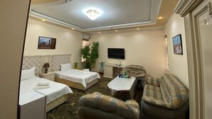 A hotel room with two beds, a sofa, a TV, and a small table. - Samarkand (Samarkand)