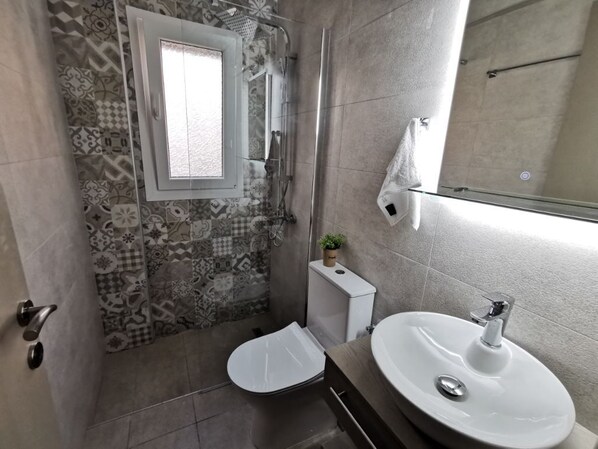 Un baño con ducha, inodoro y lavabo.