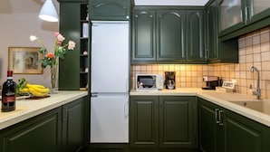 A kitchen with green cabinets, a white refrigerator, a microwave, and a coffee maker. - Pausa Verde - Recently renovated apt, private parking (Corfu)