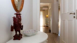 A bathroom with a white vanity, a wooden statue, and a bowl. - Le Boulevard - stylish, renovated apartment (Corfu)