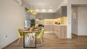 Eine moderne Küche mit Holzausstattung, einer zentralen Kochinsel und einem Essbereich mit gelben Stühlen.