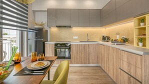 Eine moderne Küche mit Holzausziehtüren, einem eingebauten Ofen und einer Arbeitsplatte mit einer Obstschale.