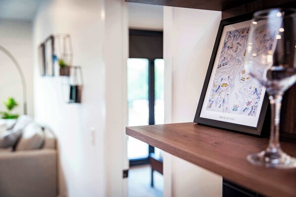 A framed map on a shelf with a wine glass in front.