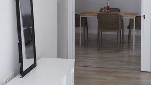 A room with a white dresser, a mirror, a dining table with chairs, and a painting on the wall. - Antonias Iris apartment (Corfu)