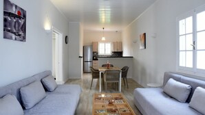A compact living space with a kitchenette, a dining area, and two sofas. - Antonias Iris apartment (Corfu)
