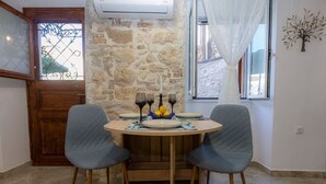 A dining area with a round table, two chairs, and a decorative centerpiece. - Volto Achilles Suite (Corfu)