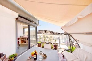 A balcony with a table, potted plants, and a sofa. - Topfloor stylish apartment with Acropolis view! (Athens)