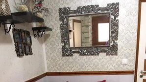 A room with a red sofa bed, a decorative mirror, and wall-mounted picture frames. - Pento Studio - Ground floor apt, located near Corfu square (Kerkira)