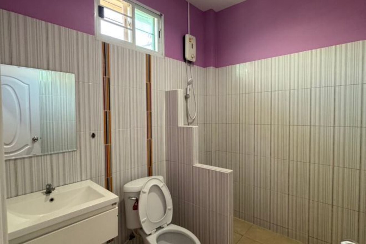 A bathroom with a white sink, a toilet, and a shower area.