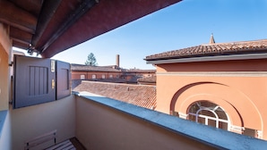 A balcony with a view of traditional buildings, a door, and a window. - HouSmart Tovaglie 9 int. 6 (Bologna)