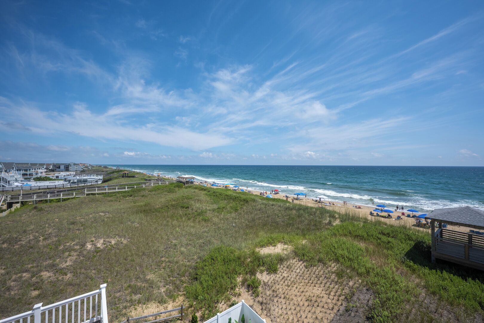 A beach with a wooden structure, a boardwalk, and a view of the ocean.