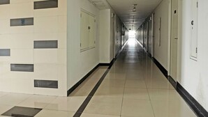 Un pasillo largo y estrecho con puertas a ambos lados, que conduce a habitaciones individuales.