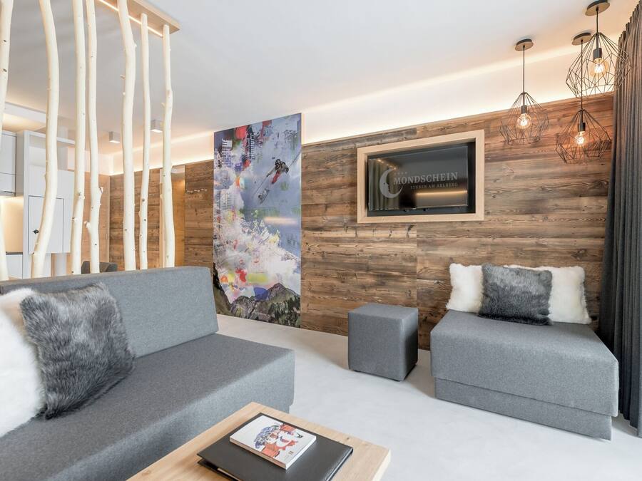A modern living room with grey sofas, a coffee table, and a large painting on the wall.