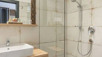 Une salle de bain moderne avec une douche à parois de verre, un meuble-lavabo en bois et un miroir au-dessus.
