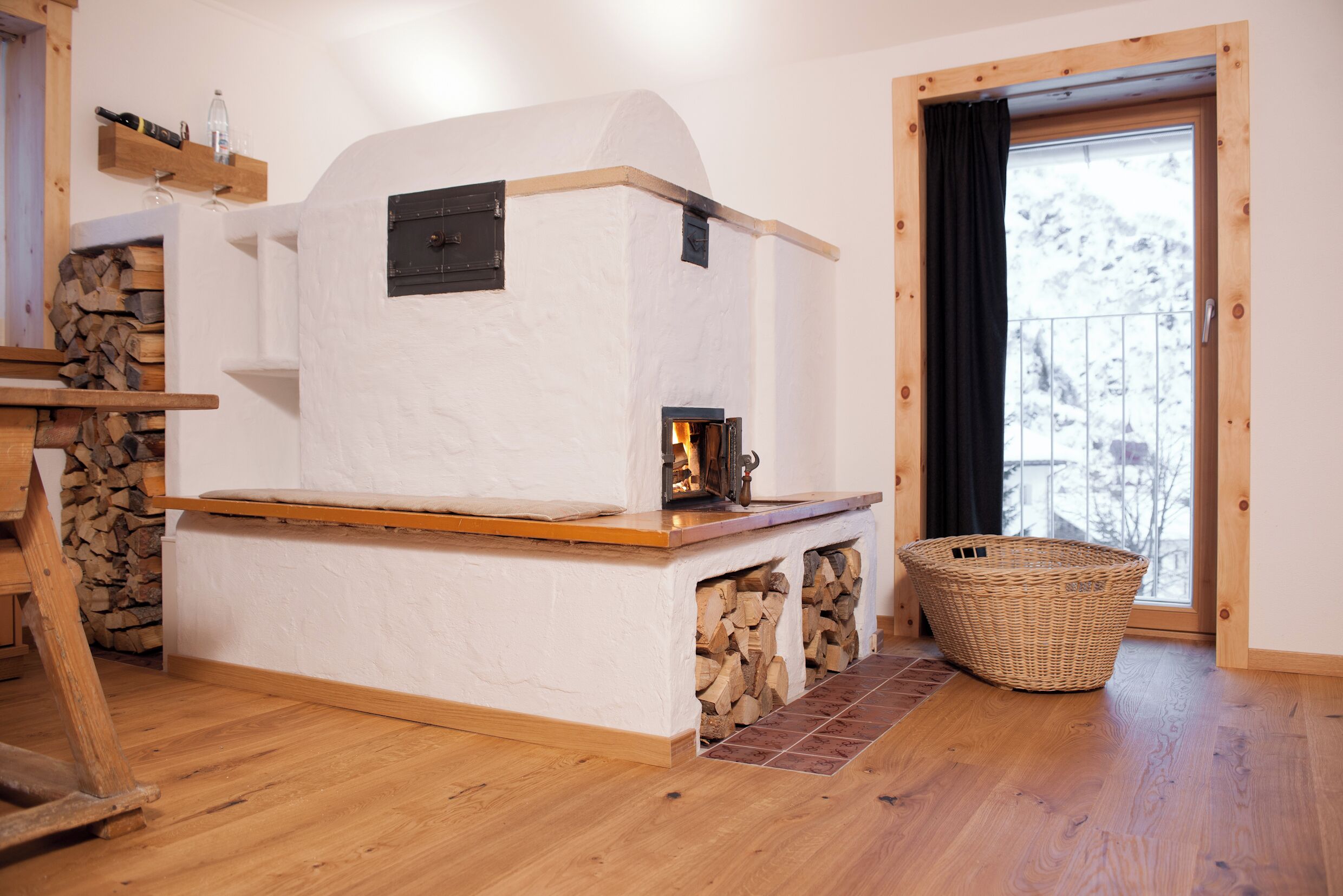 Una habitación acogedora con chimenea, suelo de madera, pared de piedra y ventana con vistas.