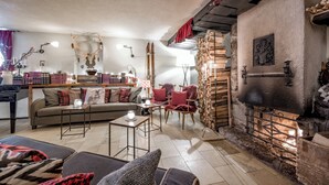 Un salon chaleureux avec une cheminée, un canapé, une table basse et une bibliothèque.