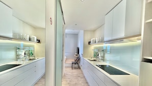 Eine moderne Küche mit zwei Spülen, einem Essbereich und Blick zum Wohnzimmer.