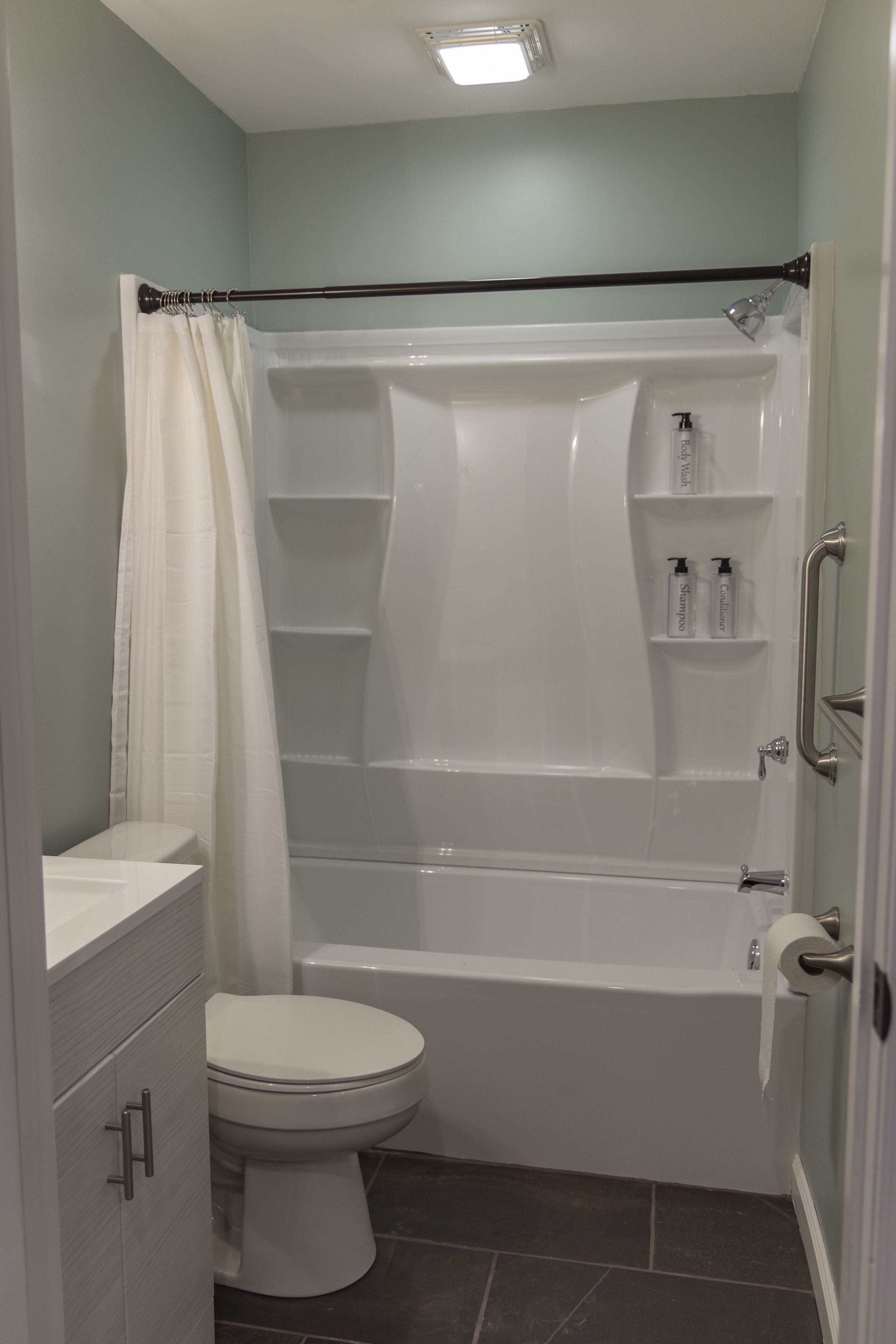 A bathroom with a bathtub, toilet, and a shower curtain.