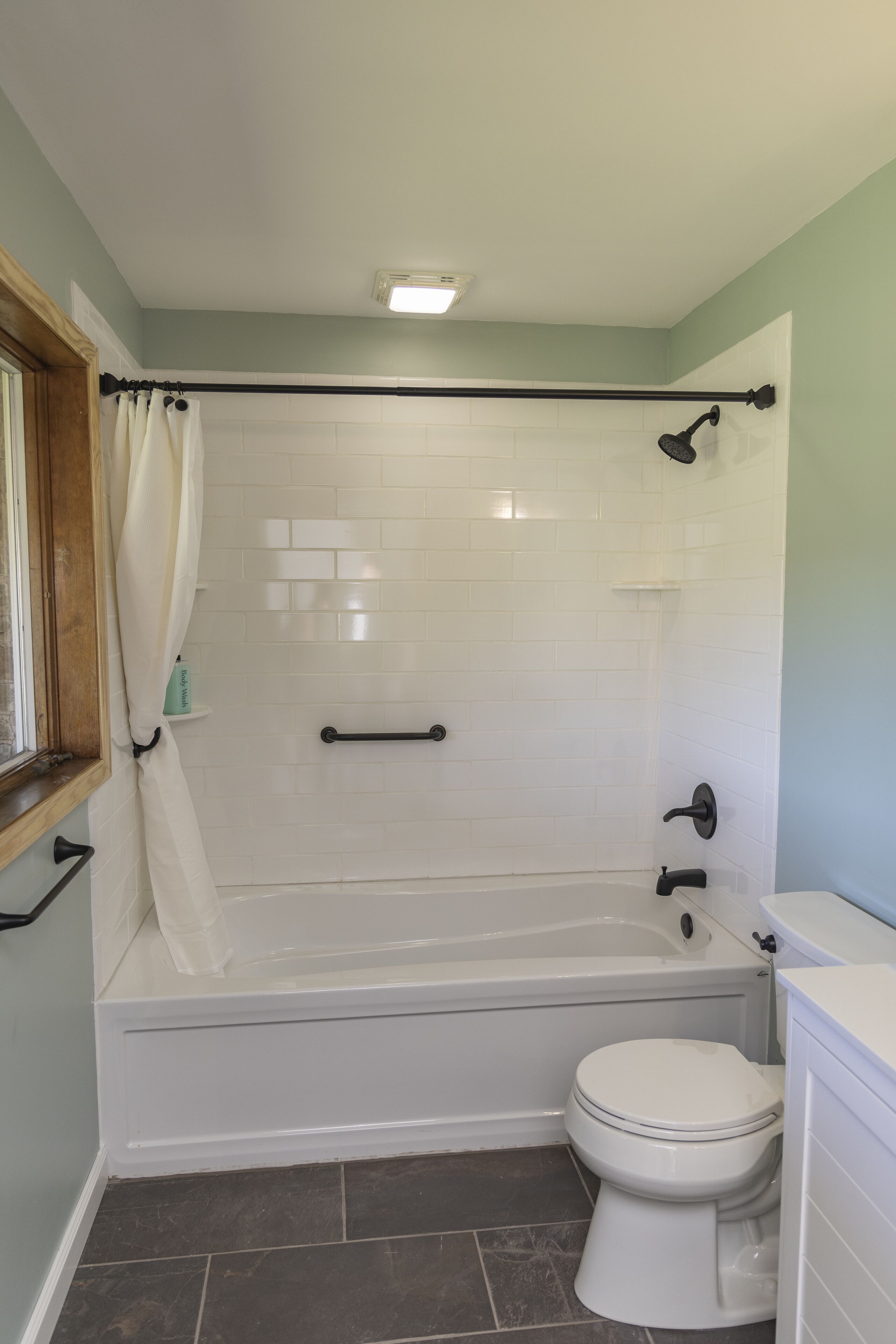 Un baño con bañera, inodoro y zona de ducha.