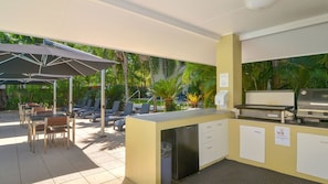 Enjoy outdoor dining and cooking in a serene setting with a central island grill and seating area.