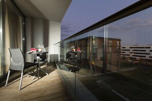 A balcony with two chairs and a table, each with a glass top and a candle. - Villa Doria  (Luxembourg City)