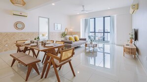 A spacious living area with a dining table, sofa, and large windows. - The Jazz Serviced Suites (George Town)
