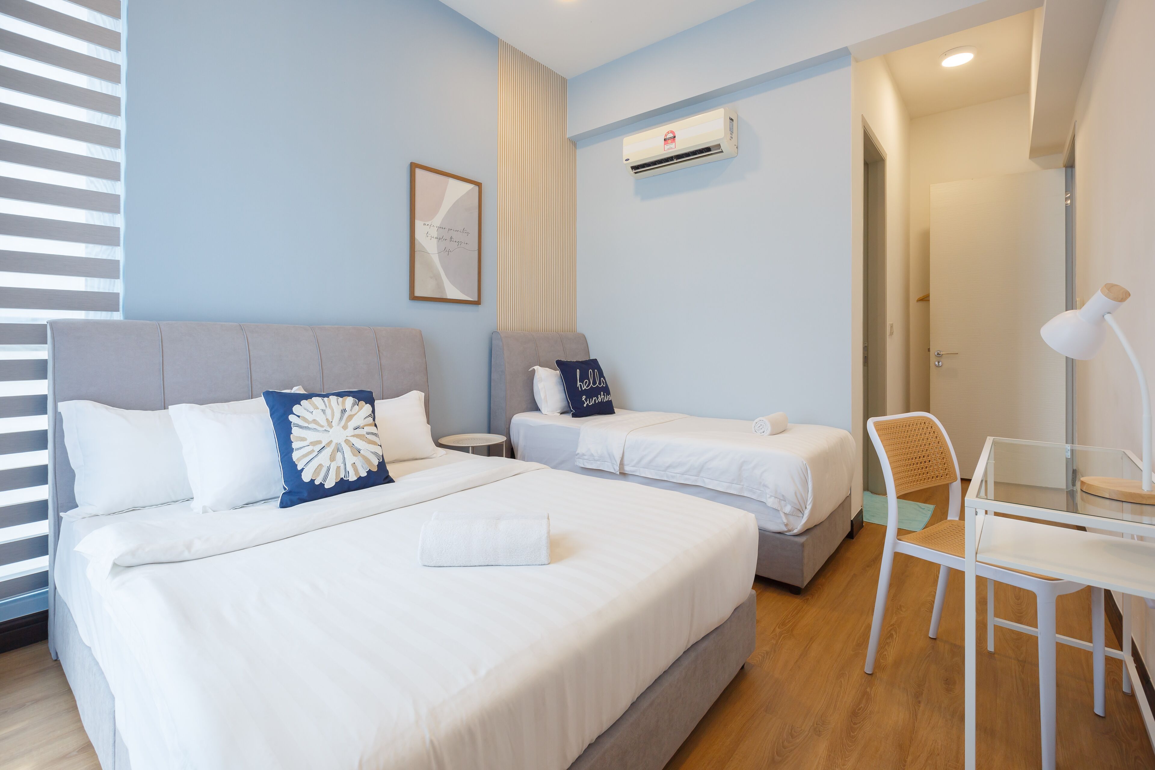 Een hotelkamer met twee bedden, een bureau en een stoel.