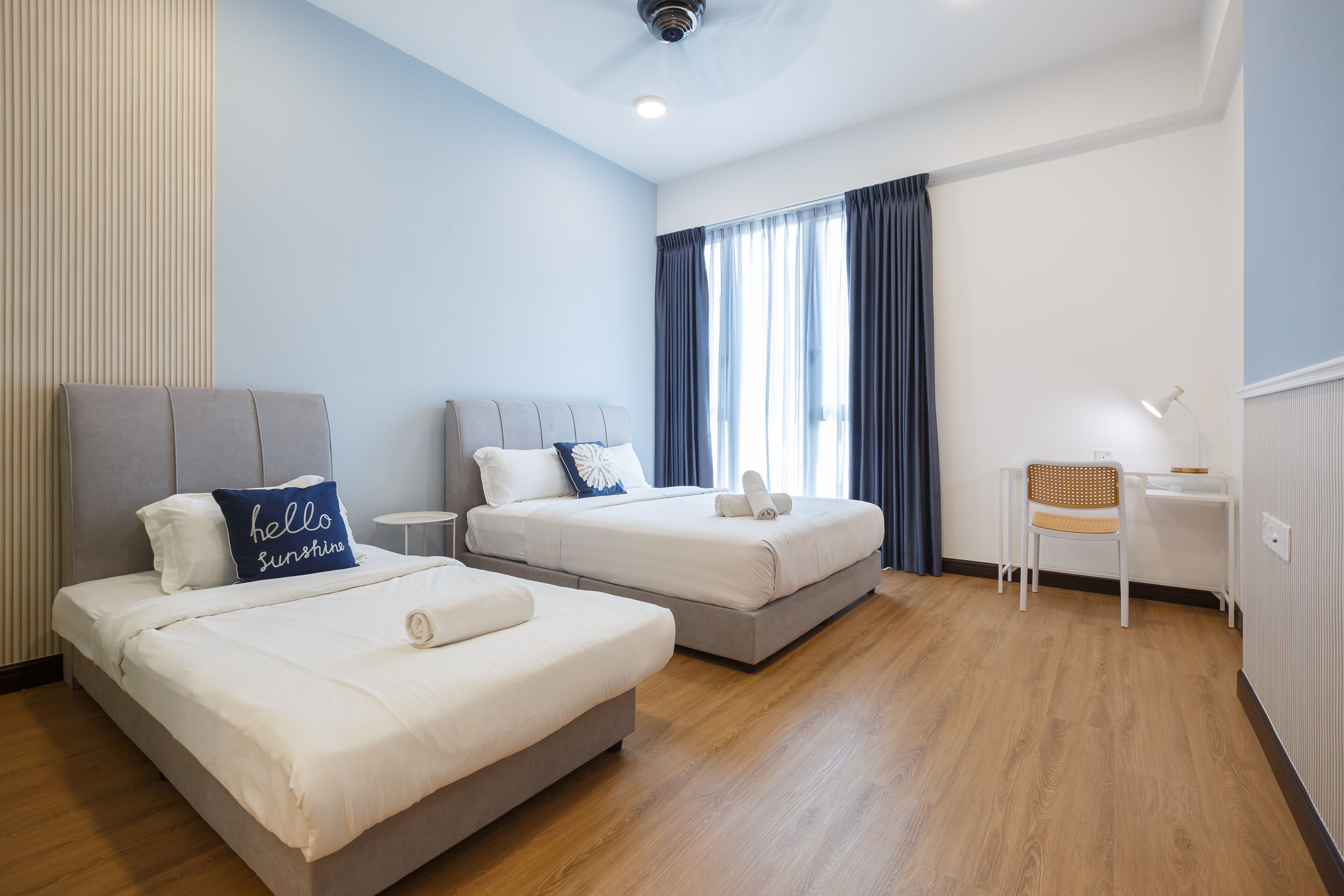 Een hotelkamer met twee bedden, een bureau en een stoel.