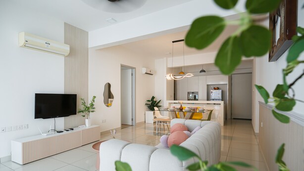 A modern living room with a flat-screen TV, a white sofa, and a dining area with a kitchen in the background. - The Jazz Serviced Suites (George Town)