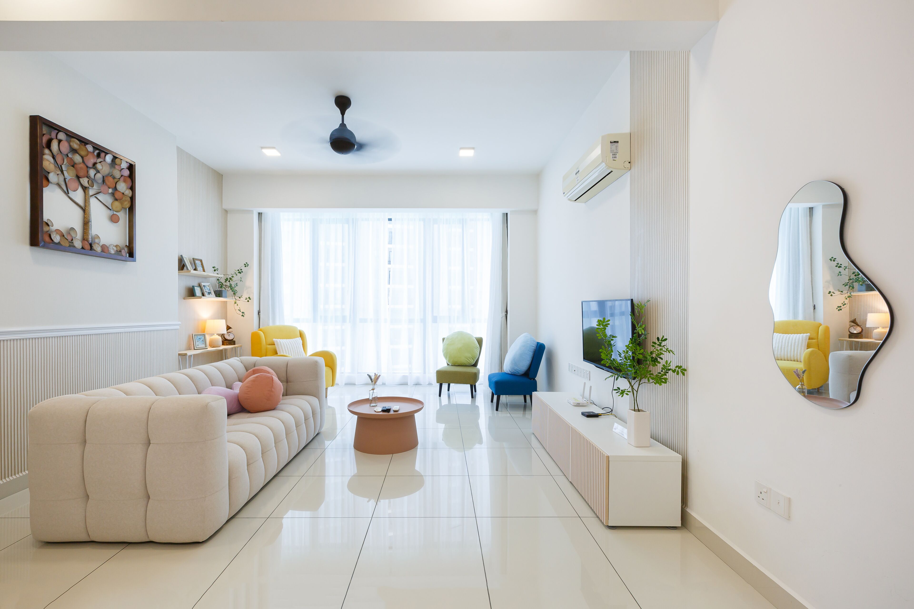 A modern living room with a sofa, armchairs, a coffee table, and a TV.